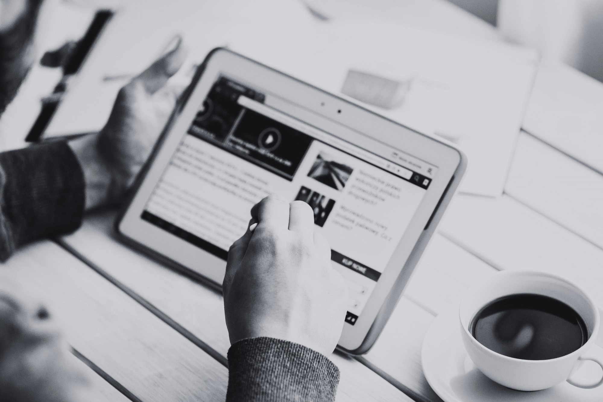 An image of someone reading online news and drinking coffe